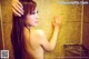 A naked woman standing in a bathroom next to a shower.
