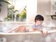 A woman sitting in a bathtub with a cigarette in her hand.