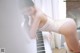 A woman in a bathing suit leaning on a piano.