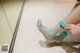 A woman putting on a pair of blue socks.