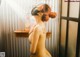 A naked woman wearing a mask in a shower.