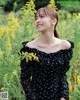 A woman standing in a field of yellow flowers.