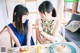 Two young women sitting at a table with plates of food.