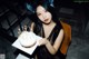 A woman holding a birthday cake with lit candles.